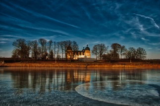 Schloss Seehof und der zugefrorene See im Winter